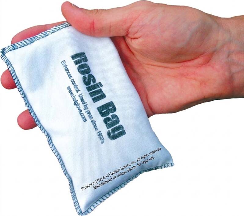 Hot Glove Extra Large baseball rosin bag gripped in a pitcher's hand, oversized white bag for maximum dry powder coverage.