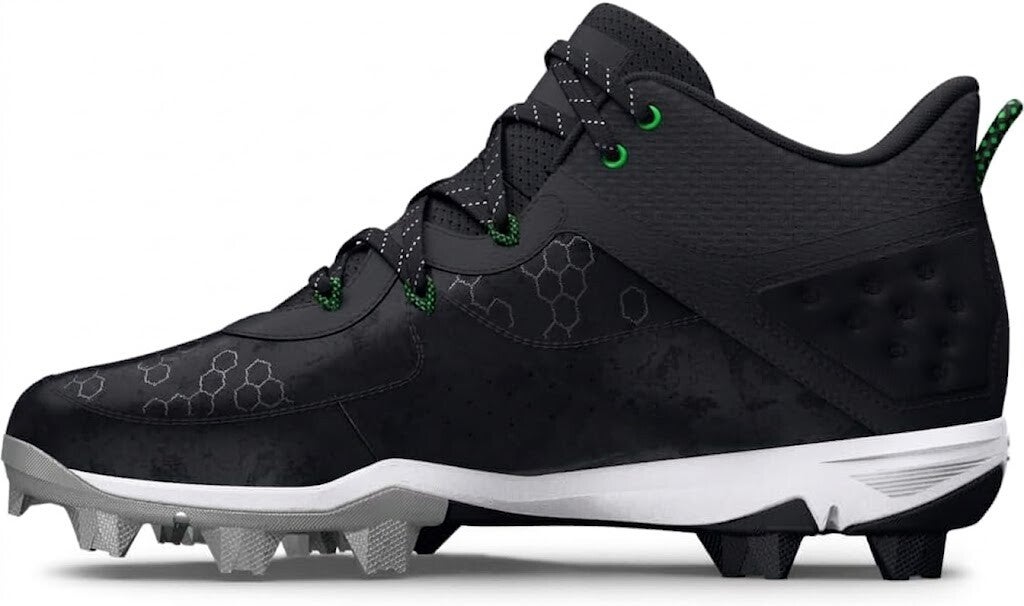 A side view of a black baseball cleat with green accents and a white midsole on a white background.