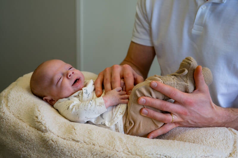 Baby osteopaat in Panningen behandelt zachtjes het buikje en de beentjes van een baby met darmkrampjes