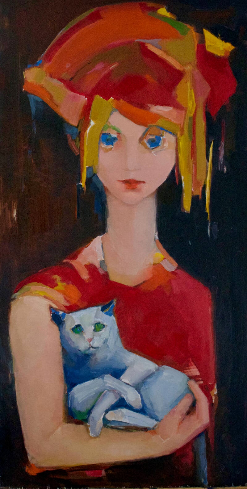 ingetogen meisje met kleurrijk haar  houdt bescherment een blauwe kat met groene ogen op haar arm