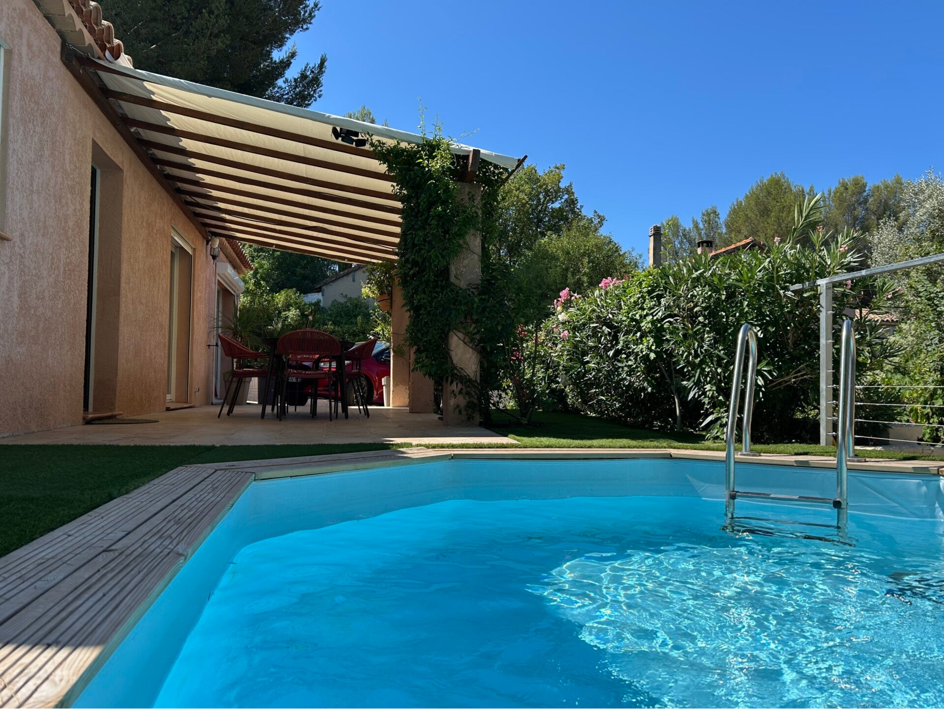 Photo de la piscine et de la terrasse avec sa toile pour abriter du soleil l'été.