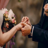 groom-putting-ring-bride-s-finger-standard-kyqyq8.jpg