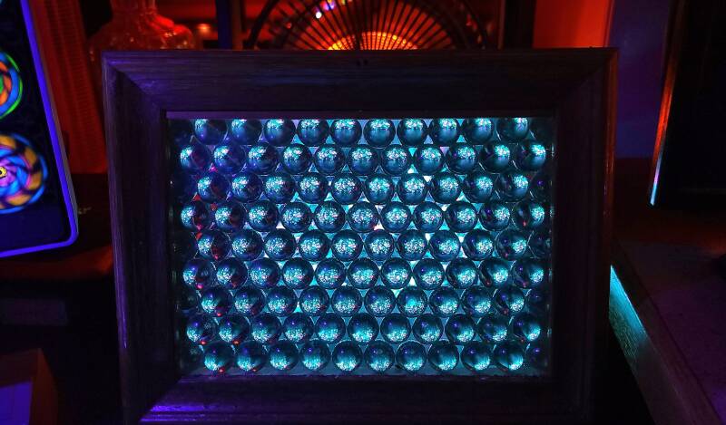 Offset marble matrix screen fixed to an open cigar box. LED analogue pixel generator.