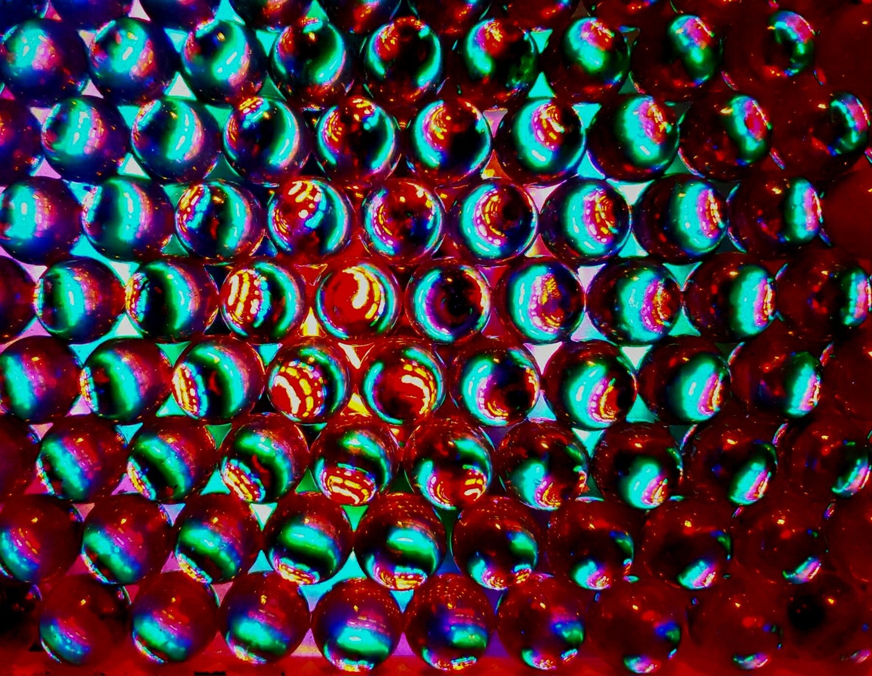 Tabletop kinetic LED light sculpture with glass marble matrix screen and colorful rotating geometric patterns.