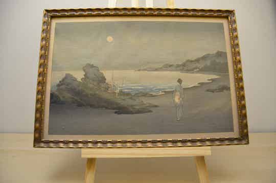 A woman sauntering on a beach by moonlight