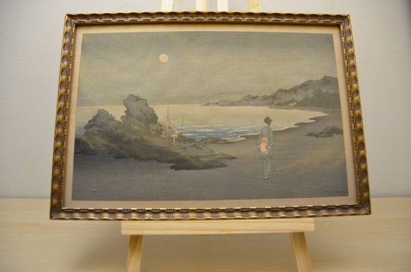 A woman sauntering on a beach by moonlight