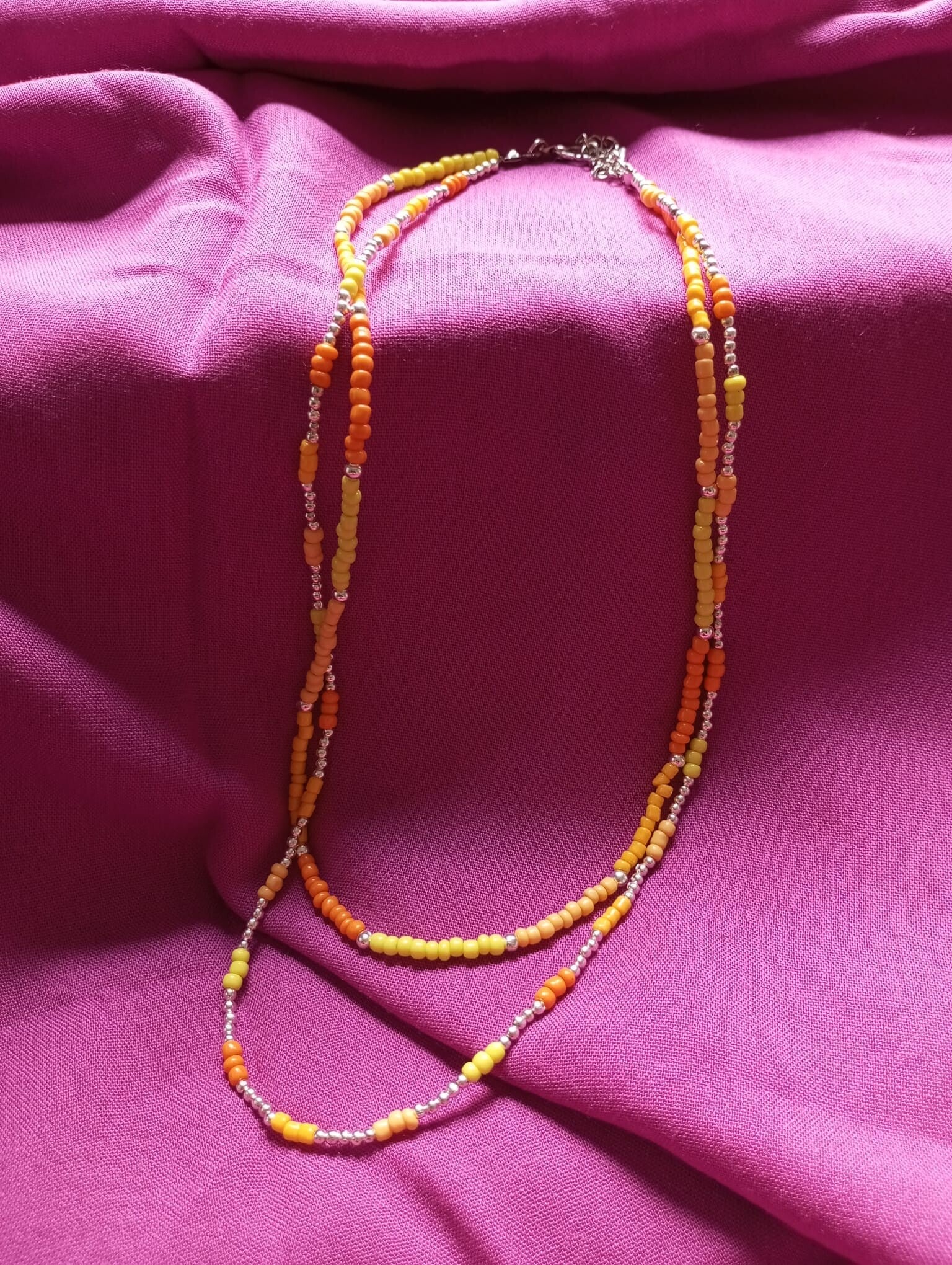 Collar doble en plateado, naranja y amarillo.