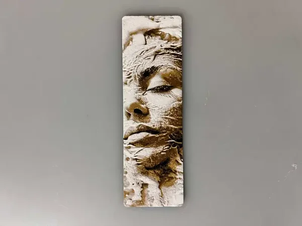 Lesezeichen: Gesicht im Sand