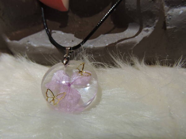 collier rond avec fleur rose et papillons dorés