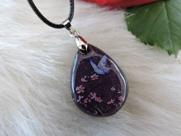 pendentif avec fleurs et papillon sur fond violet