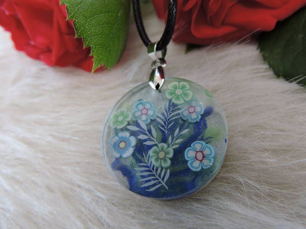 pendentif rond fleuri sur fond bleu et blanc