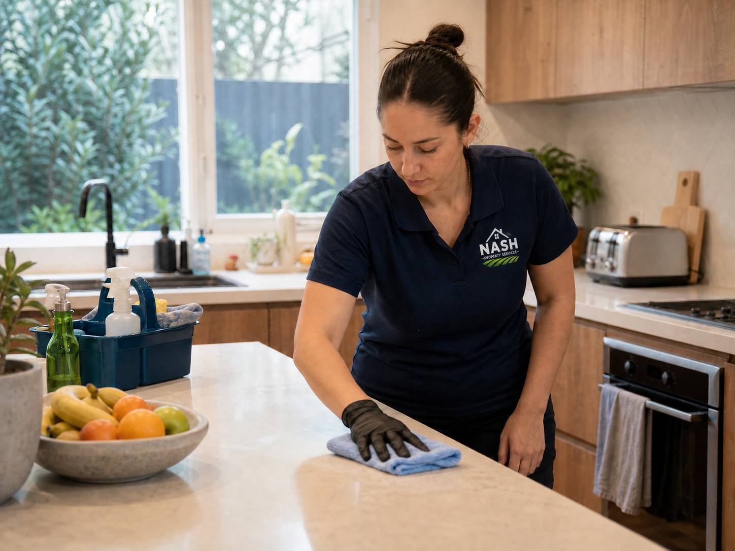 Cleaner wiping a kitchen bench in a Bayside home