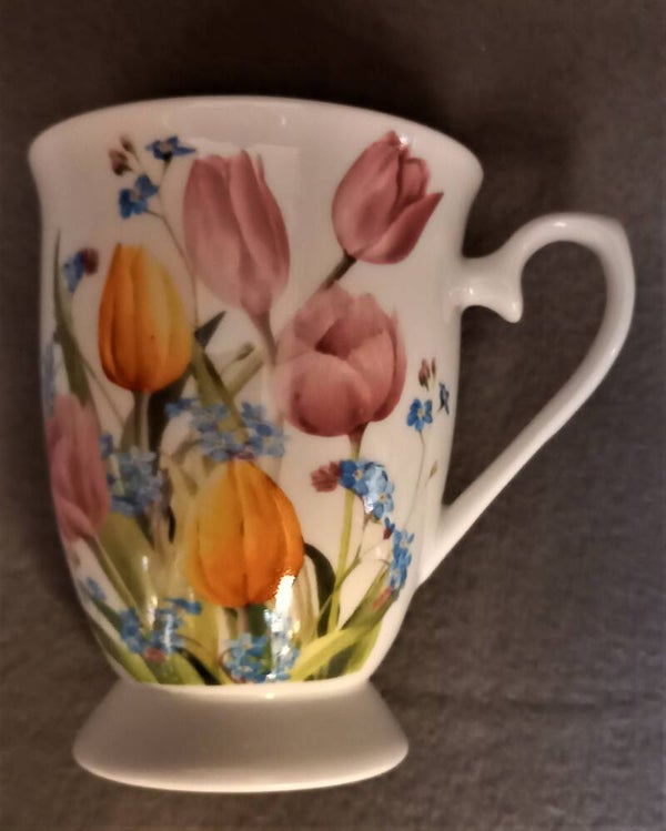 Porselein kopje met oor op voetje met tulpen