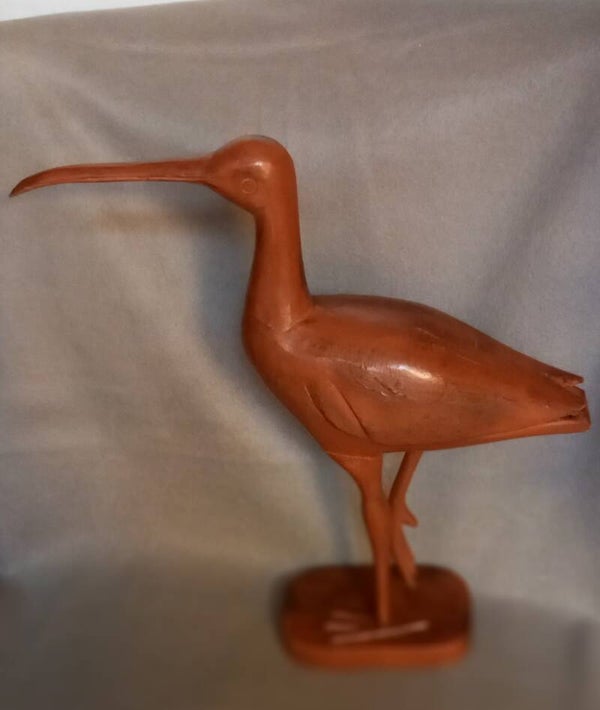 Houten vogel op voet in rood