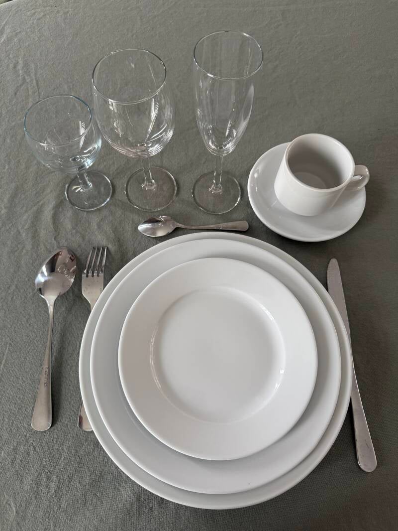 Kit prestige dressé : verre à eau, verre à vin, flûte, assiette 27 cm, assiette 25 cm, assiette 19 cm, tasse et soucoupe, couverts. Location de vaisselle en Sarthe