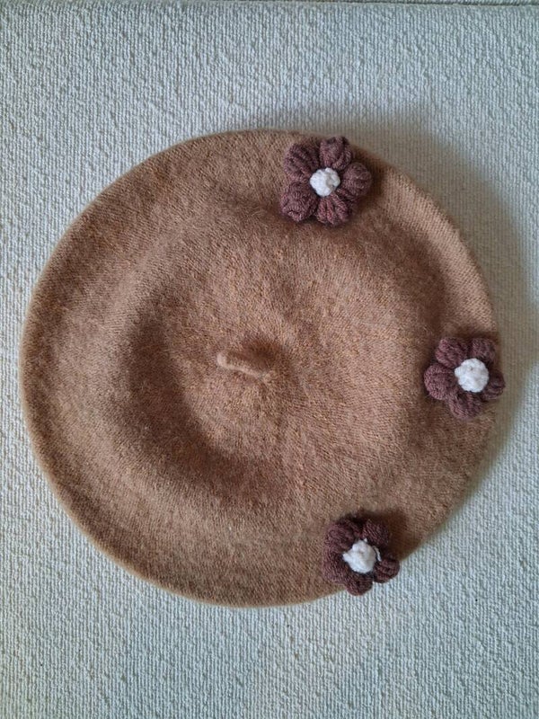Camelkleurige baret met bloemetjes.