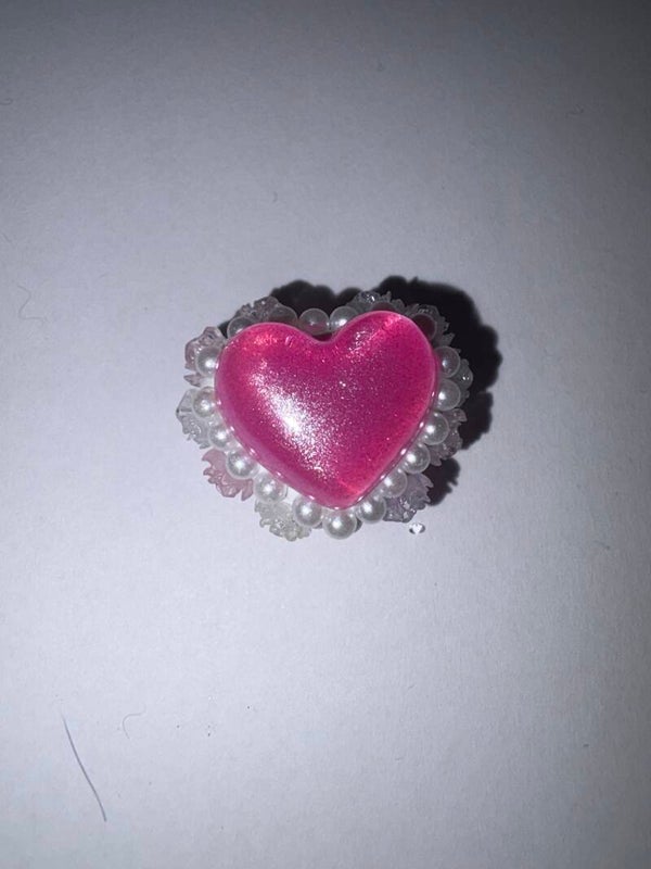 een pink hartje met rondom parels