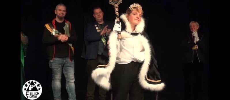 Evelyne presenteert de scepter op het podium — beeld met Filip Filmkes-watermerk