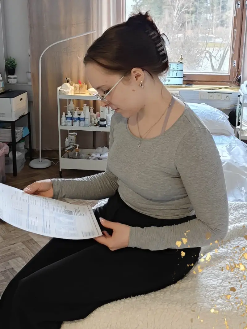 Asiakas tarkastelee InBody-mittaustuloksia paperilta hoitotilassa, kuvastaen henkilökohtaista ohjausta.