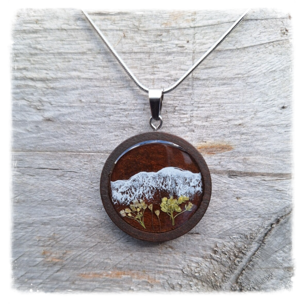 Zilverkleurige ketting met bergscene in houten hanger met gedroogde bloemen