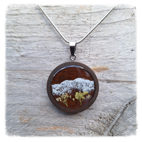 Zilverkleurige ketting met bergscene in houten hanger met gedroogde bloemen