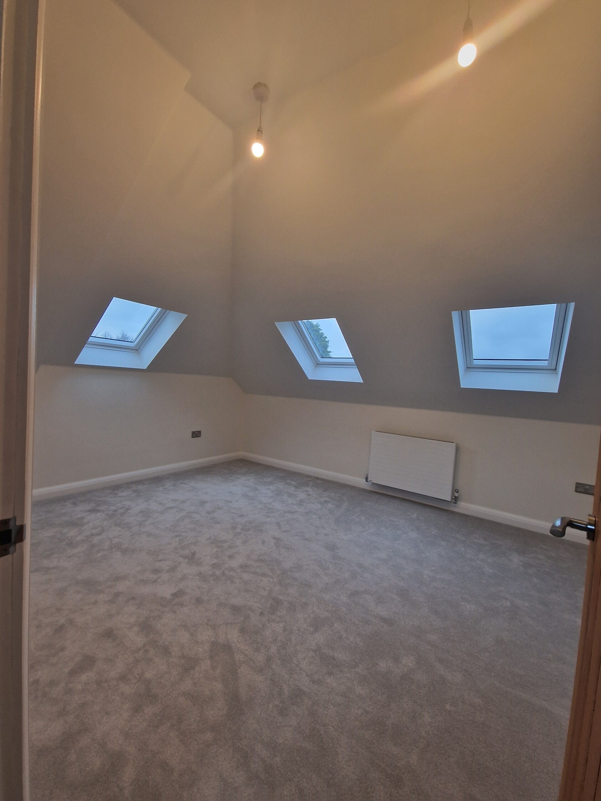 Completed loft conversion with three roof windows and fitted carpet