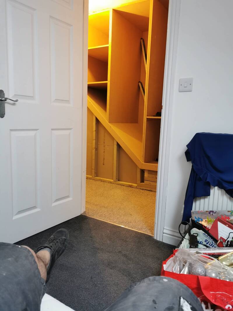 Open shelving inside bespoke above-stairs storage in East Grinstead