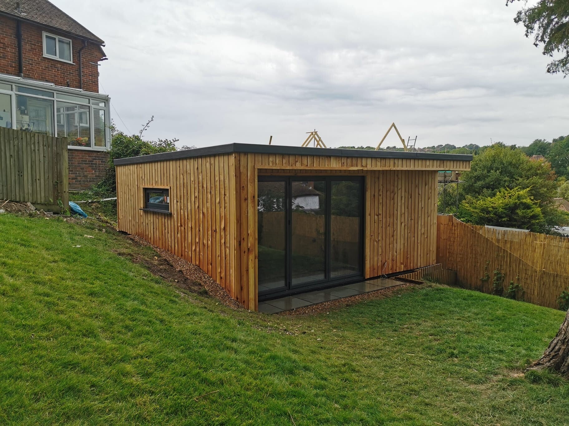 Timber-clad garden room with dark glazed doors in East Grinstead Timber-clad garden room with dark glazed doors in East Grinstead