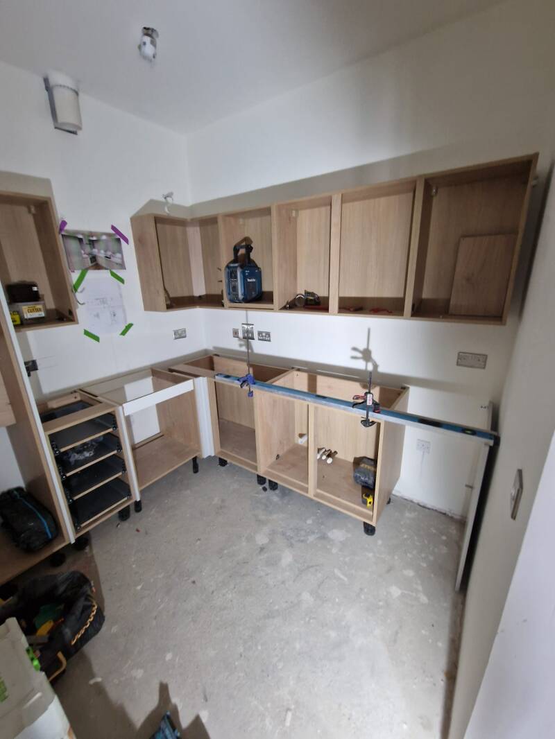 Horsham flat kitchen during refurbishment with exposed cabinets and walls
