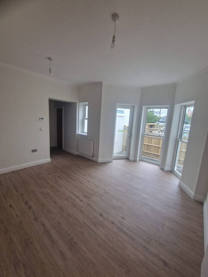 Refurbished Horsham living room with light walls and timber-effect flooring