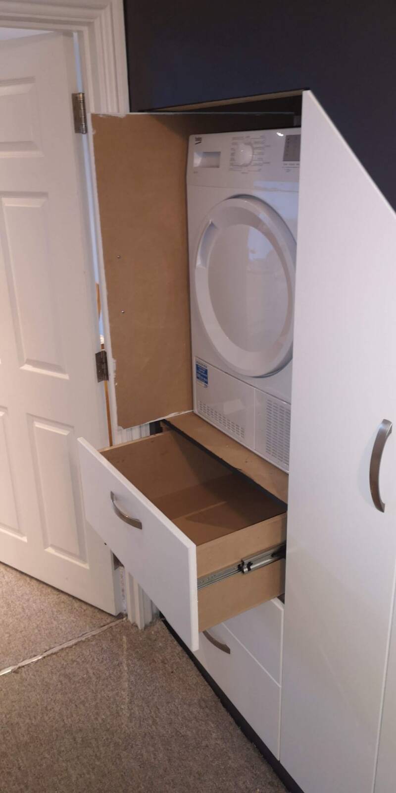 Open understairs utility cupboard with appliance space and pull-out drawer in East Grinstead