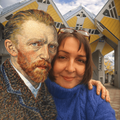 Artist Erika Stanley with a Vincent van Gogh bust in front of Rotterdam Cube Houses, representing the first step of the creative process: The Spark.