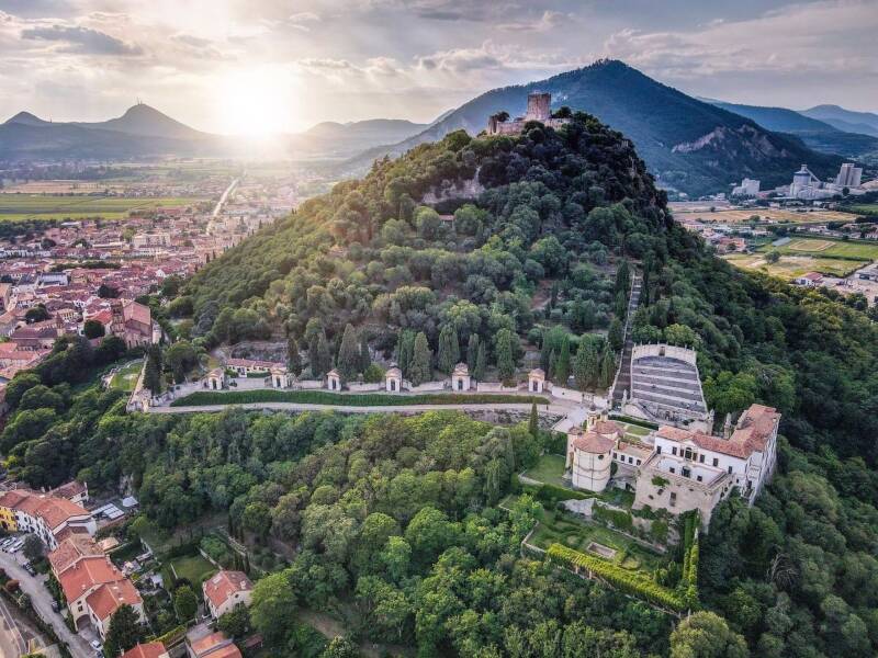 Panoramic aerial photograph showing the walled city, the castle, and the profiles of the Euganean Hills.