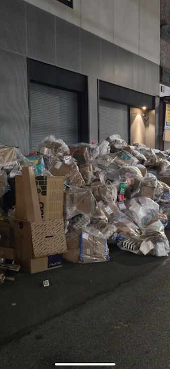 Large pile of cardboard boxes, plastic bags, and mixed commercial business waste ready for junk removal