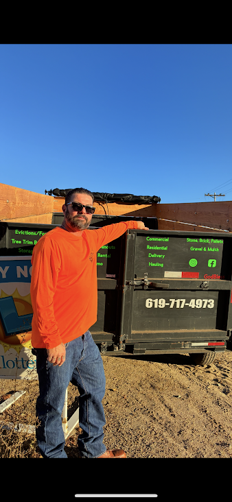 Dominic Miranda, owner of DBM Hauling, posing by dump trailer with services like evictions, tree trim, commercial/residential hauling, and rentals in El Cajon, California.