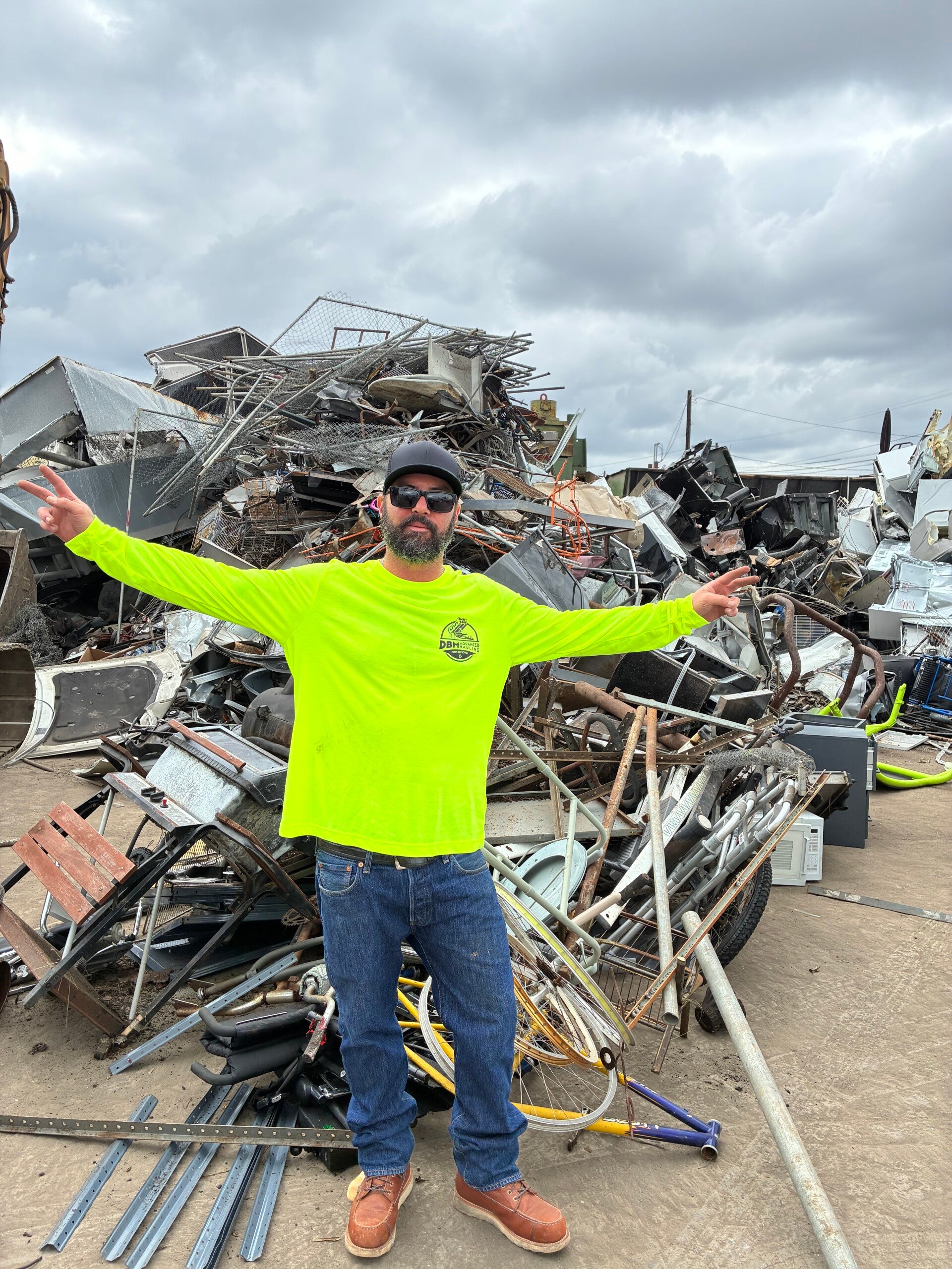 Dominic Miranda, owner of DBM Hauling, posing with branded dump trailer for junk removal services in San Diego, California.