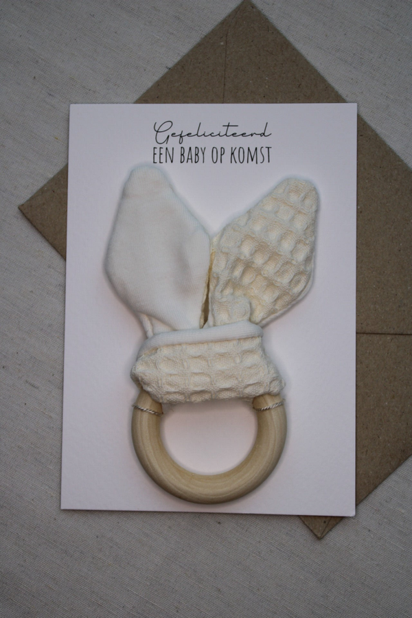 Kaart 'bijtring wafelstof/ tricotstof ecru, een baby op komst'