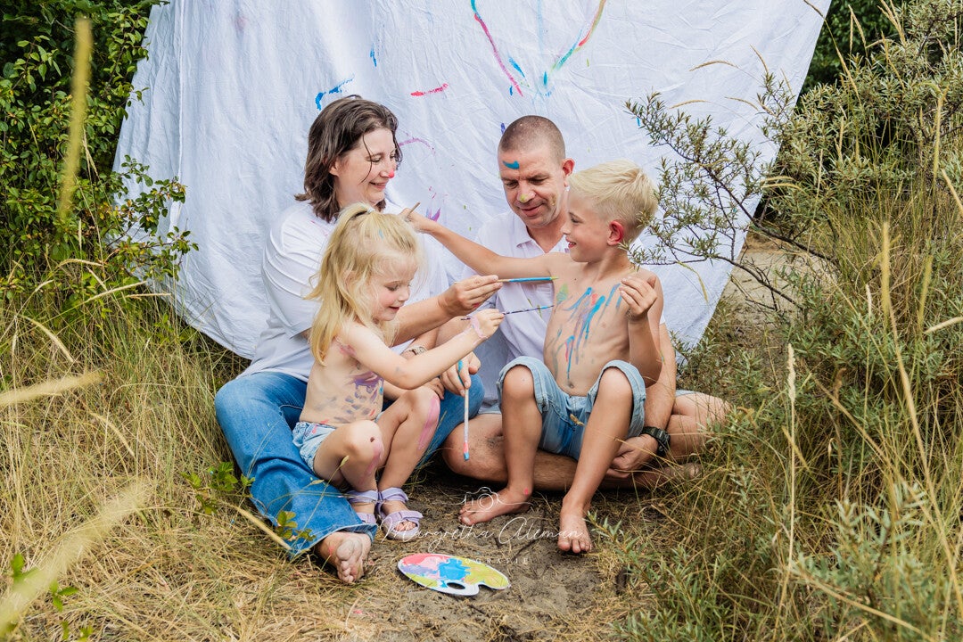 Gezin met kinderen loopt over het strand tijdens golden hour