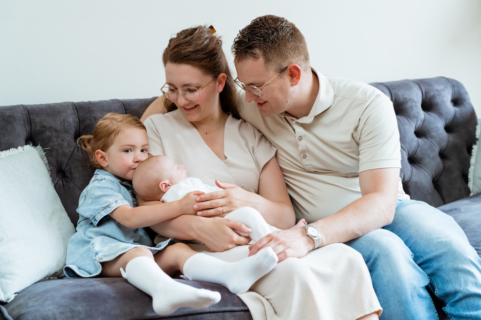 Gezin met pasgeboren baby op de bank tijdens newbornshoot in Ouddorp