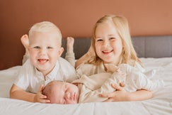 Gezin met pasgeboren baby op de bank tijdens newbornshoot in Ouddorp