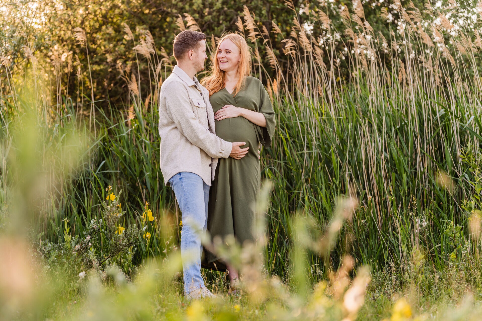Zwangere vrouw tussen bloemen in brabant tijdens golden hour