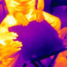 Wärmebild einer Person mit Händen über einem Objekt, das Wärme abstrahlt, in lila und orange Farbtönen, Kontext Blog Jenseitskontakte Jana Lorenz.