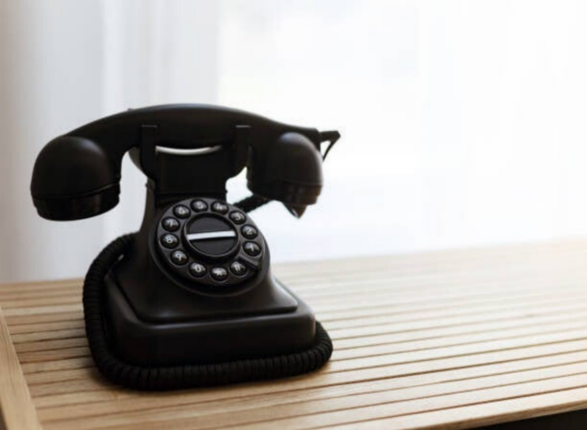 Ein vintage Telefon liegt auf einem Holztablett, das die Eleganz und den Charme vergangener Zeiten widerspiegelt, im Kontext mit Jenseitskontakte Jana Lorenz.