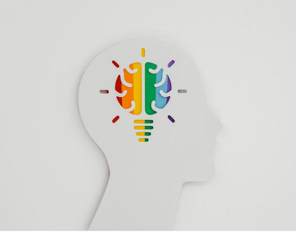 Silhouettenprofil eines Kopfes mit einer bunten Glühbirne in Form eines Gehirns im Inneren, symbolisiert Optimismus im Blog Jenseitskontakte von Jana Lorenz.