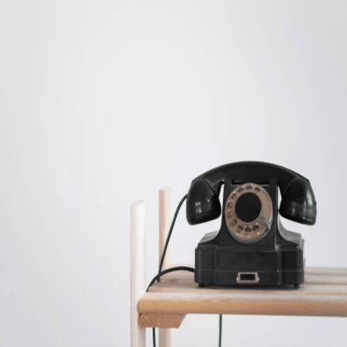 Vintage-Telefon mit Wählscheibe und Hörer auf Holzuntergrund, im Kontext mit Jenseitskontakte Jana Lorenz.
