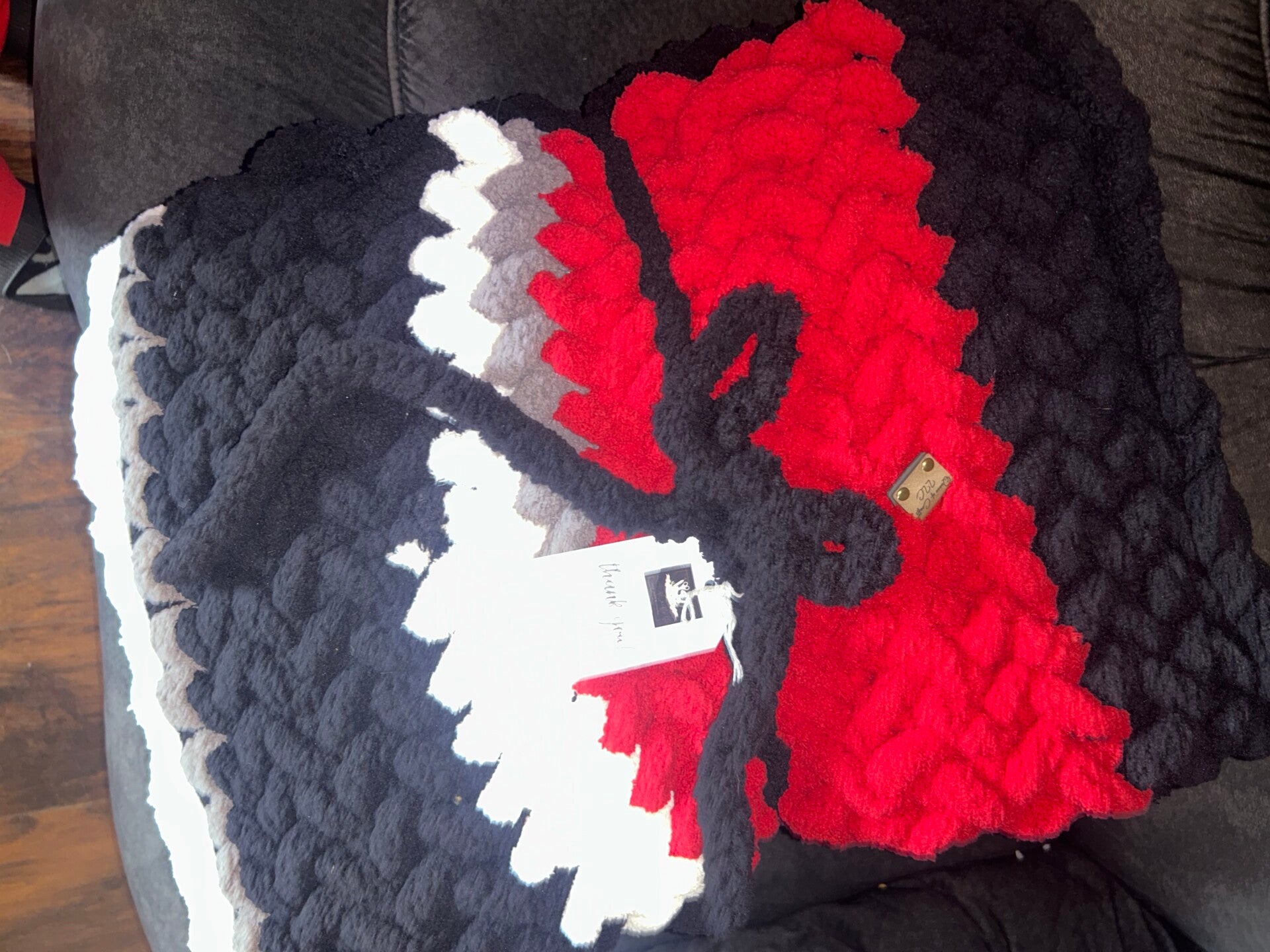 Large red, white, black, and grey blanket with a pillow