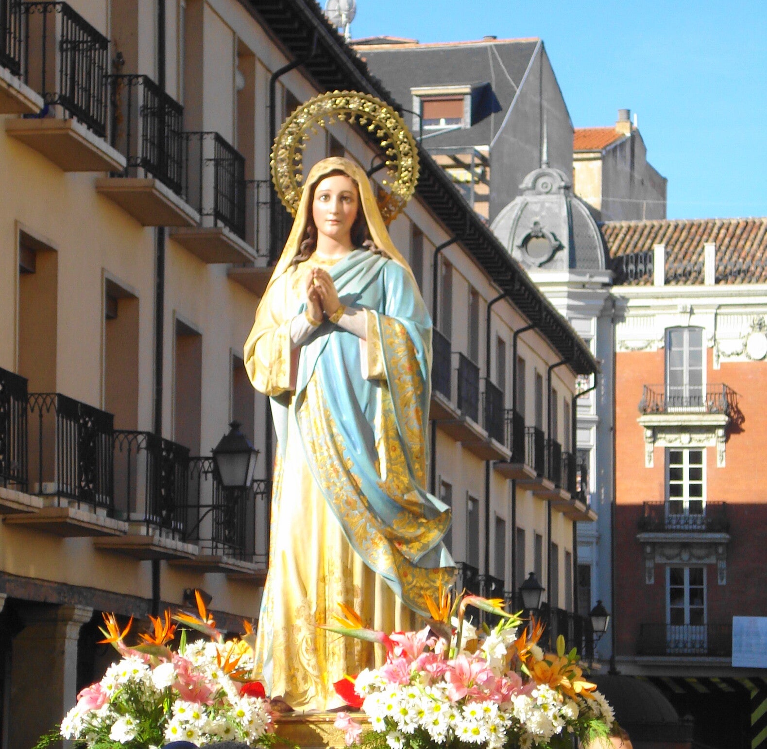 La Virgen del Rompimiento, talla anónima de 1929, con manto azul, vestido claro y corona, sobre un paso de flores en la Semana Santa de Palencia, ya sin el velo de luto.