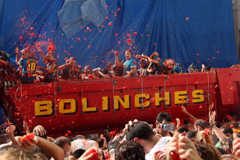 Camión descargando tomates sobre la multitud durante La Tomatina de Buñol, Valencia