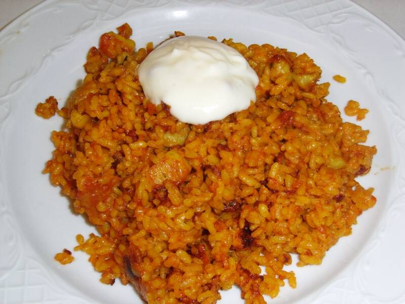 Arròs a banda, arroz seco y suelto cocido en caldo de pescado servido con alioli .