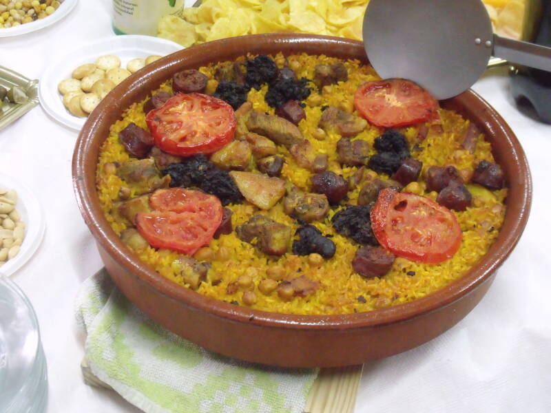 Arròs al forn en cazuela de barro con garbanzos, botifarra negra, patata y tomate, gratinado al horno.